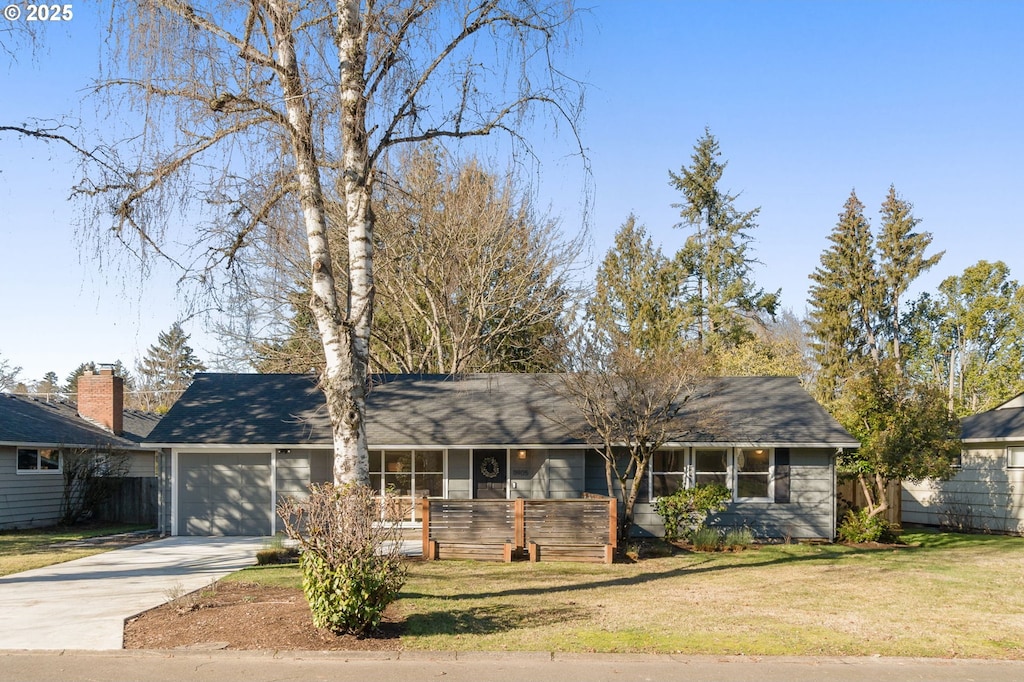 single story home featuring a garage and a front lawn