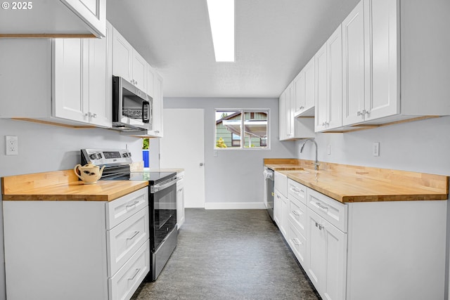 6255 SW Mad Hatter Ln, Beaverton, OR 97008 - kitchen with appliances with stainless steel finishes, wood counters, and white cabinetry