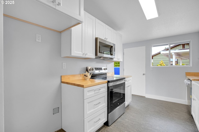 6255 SW Mad Hatter Ln, Beaverton, OR 97008 - kitchen with appliances with stainless steel finishes, white cabinets, and wooden counters