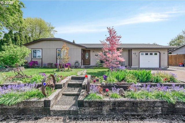 ranch-style home featuring fence, driveway, a front yard, and a garage