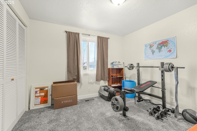 exercise room featuring baseboards and a textured ceiling
