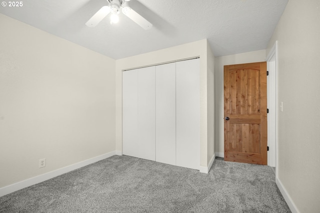 unfurnished bedroom featuring a ceiling fan, baseboards, carpet, and a closet