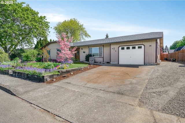 ranch-style house with a garage, fence, driveway, and roof with shingles