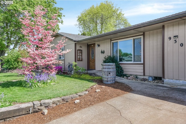 view of exterior entry with a yard