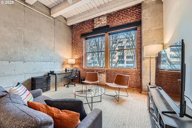 living area featuring beamed ceiling, wood-type flooring, and brick wall