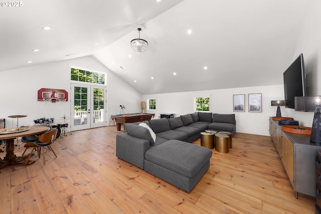 living room featuring high vaulted ceiling, an inviting chandelier, light wood-type flooring, and french doors