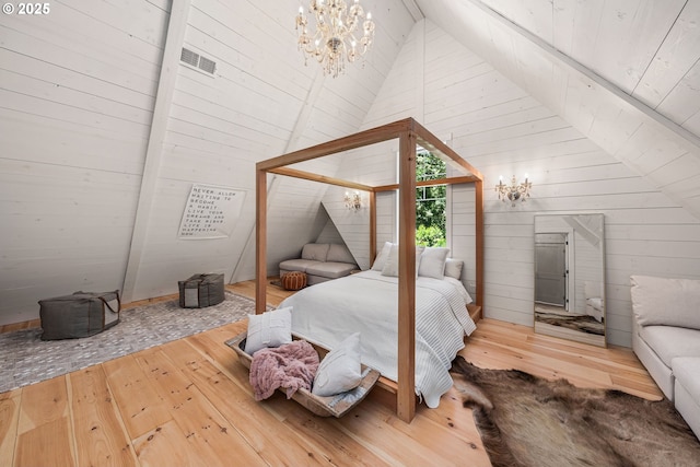 bedroom featuring wood-type flooring, a chandelier, high vaulted ceiling, and wood walls