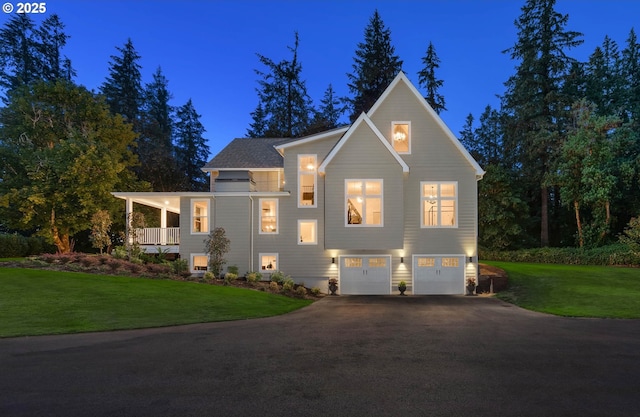 view of front of house featuring a garage, a front lawn, and covered porch