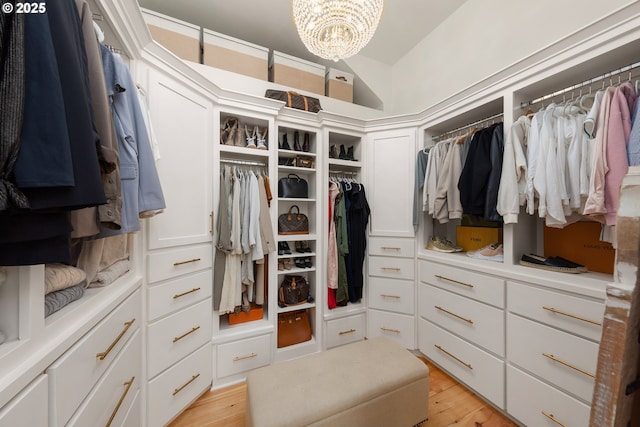 spacious closet featuring a chandelier and light hardwood / wood-style flooring