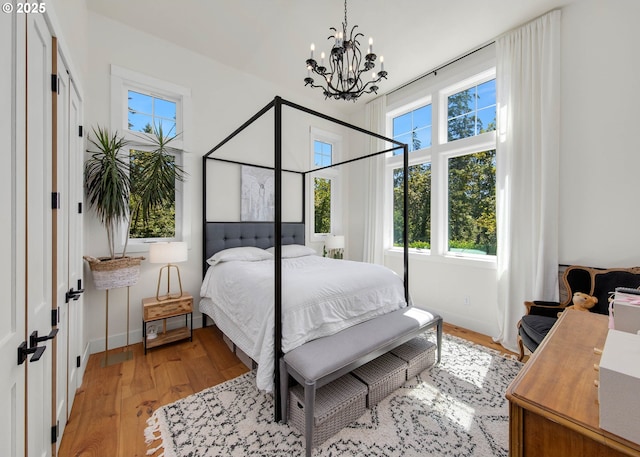 bedroom featuring a notable chandelier and light hardwood / wood-style floors