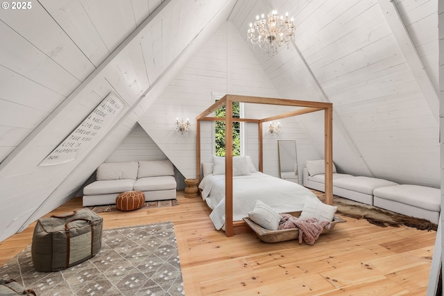 bedroom featuring an inviting chandelier, lofted ceiling, wooden walls, and hardwood / wood-style floors