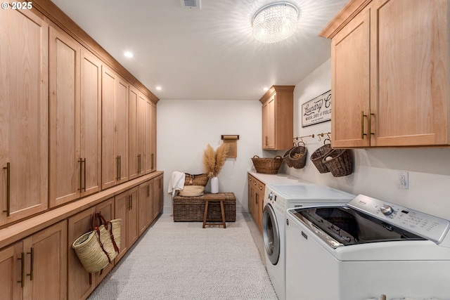 laundry room with cabinets and washing machine and clothes dryer