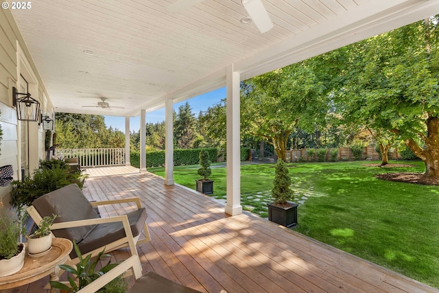 wooden deck with ceiling fan and a lawn