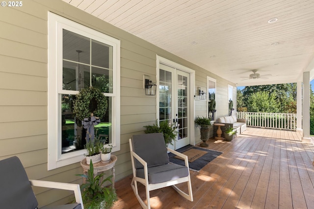 wooden terrace with ceiling fan and covered porch