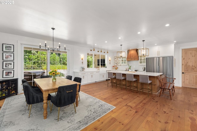 dining space with an inviting chandelier and light hardwood / wood-style flooring