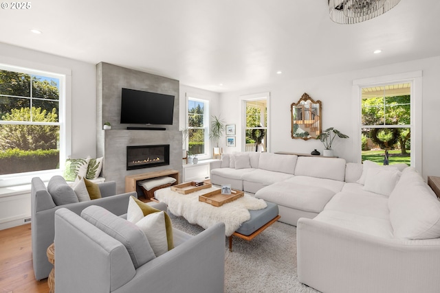 living room featuring a large fireplace and light wood-type flooring