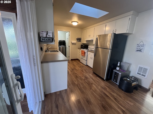 kitchen featuring a skylight, dark wood finished floors, white range with electric cooktop, visible vents, and freestanding refrigerator