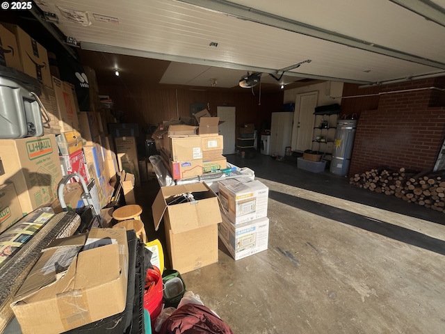 garage with a garage door opener, secured water heater, and wooden walls