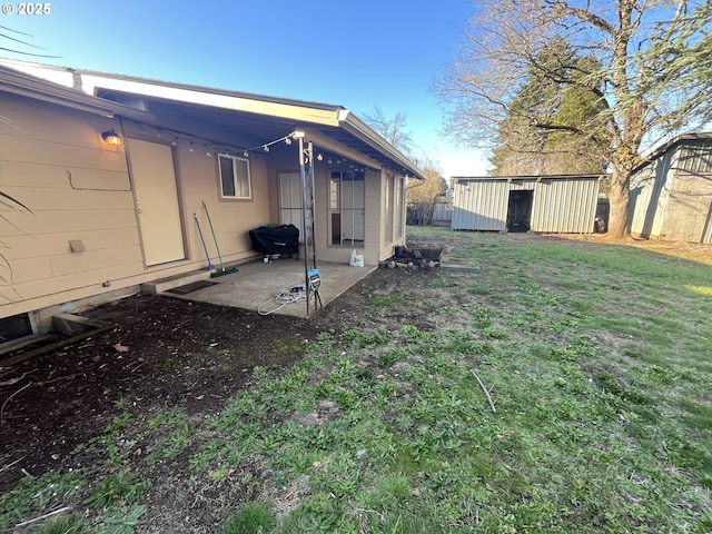 view of yard featuring an outbuilding, a patio area, and an outdoor structure