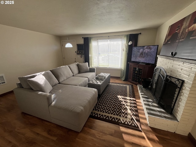 living room featuring a textured ceiling, dark wood-style flooring, and a fireplace