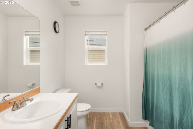 full bathroom featuring visible vents, vanity, wood finished floors, toilet, and baseboards