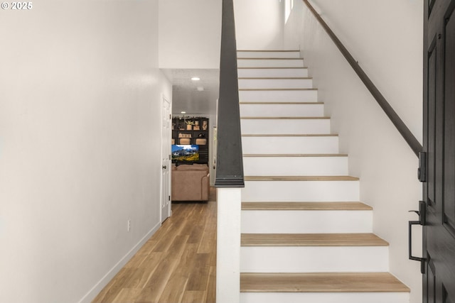 stairs with recessed lighting, baseboards, and wood finished floors
