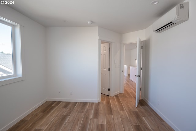 124 65th Pl, Springfield, OR 97478 - unfurnished bedroom featuring a wall mounted AC and light wood finished floors