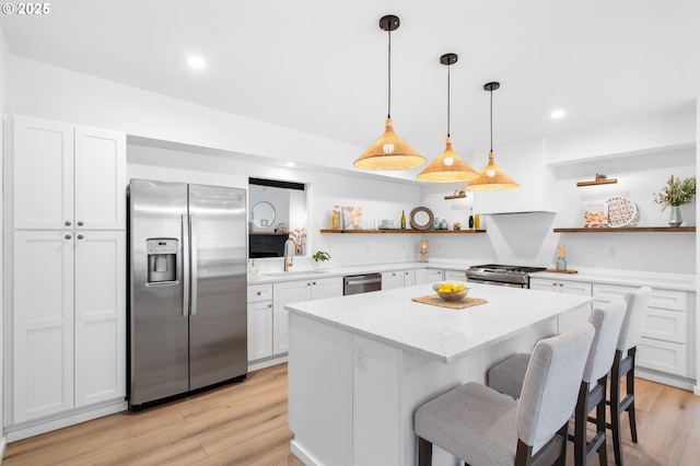 kitchen with stainless steel appliances, white cabinetry, pendant lighting, and a center island