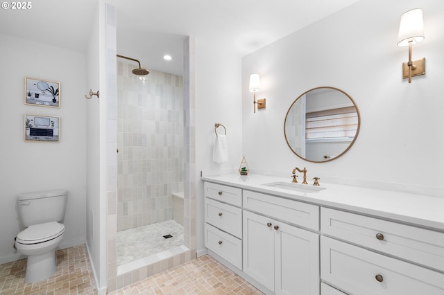 bathroom with toilet, tile patterned flooring, tiled shower, and vanity