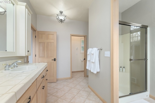 bathroom with tile patterned floors, vanity, and an enclosed shower