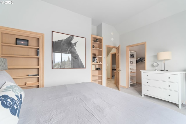 carpeted bedroom with a walk in closet and lofted ceiling