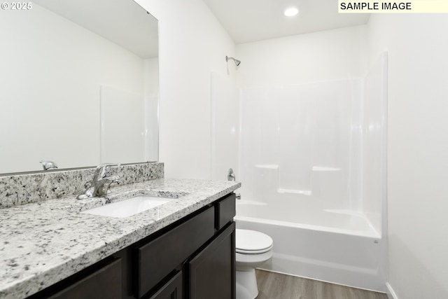 full bathroom featuring wood-type flooring, vanity, shower / bath combination, and toilet