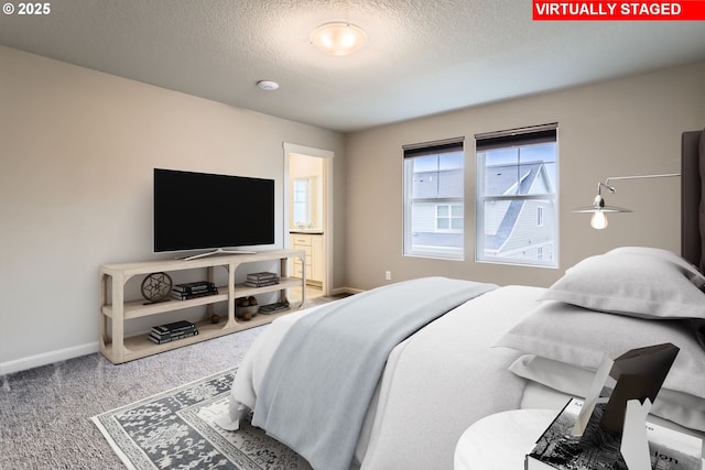 bedroom with ensuite bath, carpet, and a textured ceiling