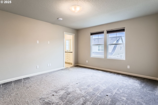 carpeted spare room featuring a textured ceiling