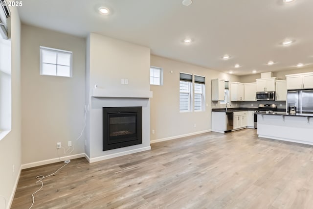 kitchen featuring white cabinetry, appliances with stainless steel finishes, and light wood-type flooring