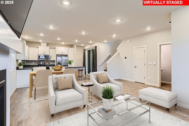 living room with light hardwood / wood-style floors and sink