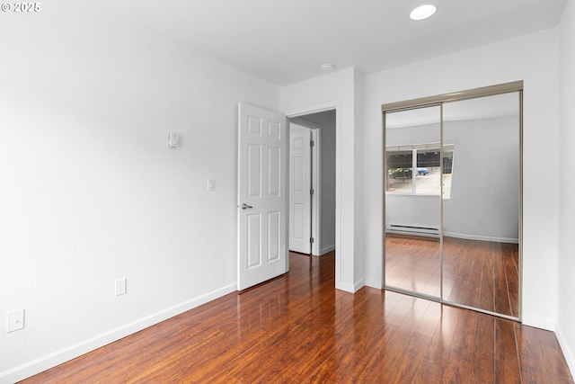 9455 SW 146th Ter Unit D 2, Beaverton, OR 97007 - unfurnished bedroom with baseboard heating, a closet, baseboards, and hardwood / wood-style floors