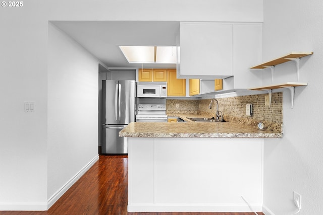 9455 SW 146th Ter Unit D 2, Beaverton, OR 97007 - kitchen with white appliances, a sink, dark wood-style floors, baseboards, and a peninsula