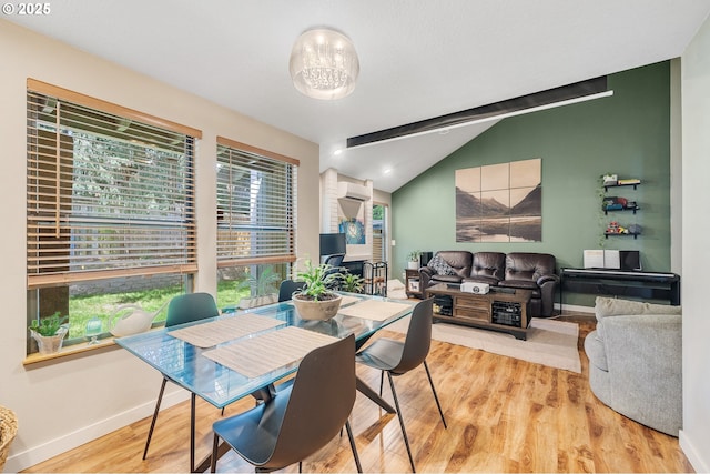 dining room featuring baseboards, lofted ceiling with beams, a healthy amount of sunlight, and wood finished floors