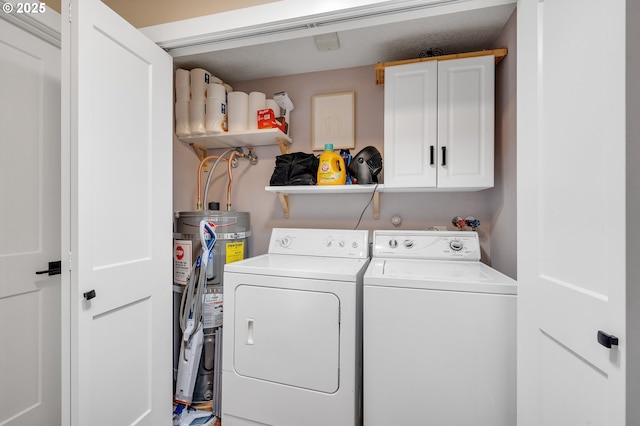 washroom featuring water heater, cabinet space, and washing machine and dryer