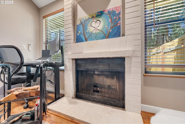 interior details featuring baseboards, wood finished floors, and a fireplace