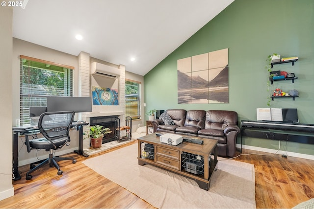 living room featuring wood finished floors, a wall mounted air conditioner, a fireplace with raised hearth, baseboards, and high vaulted ceiling
