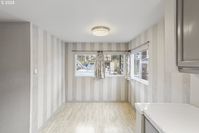 unfurnished dining area featuring a healthy amount of sunlight and light hardwood / wood-style flooring