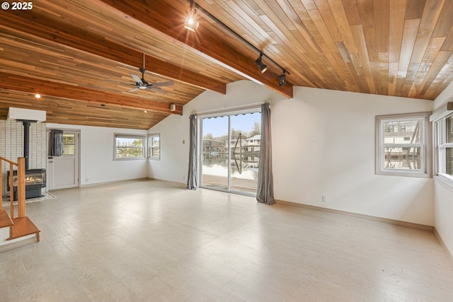 unfurnished living room with ceiling fan, vaulted ceiling with beams, a wood stove, and wood ceiling