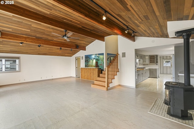 unfurnished living room featuring wood ceiling, ceiling fan, track lighting, and a wood stove