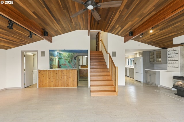 unfurnished living room featuring vaulted ceiling, rail lighting, ceiling fan, wooden ceiling, and light wood-type flooring