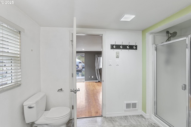 bathroom with toilet and a shower with shower door