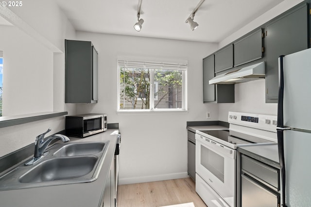 20910 Fawn Ct Unit 8, West Linn, OR 97068 - kitchen featuring white electric range oven, stainless steel microwave, freestanding refrigerator, under cabinet range hood, and light wood-style flooring