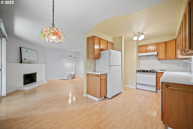 621 SE 121st Ave Unit 29, Vancouver, WA 98683 - kitchen with white appliances, under cabinet range hood, decorative backsplash, light wood finished floors, and open floor plan