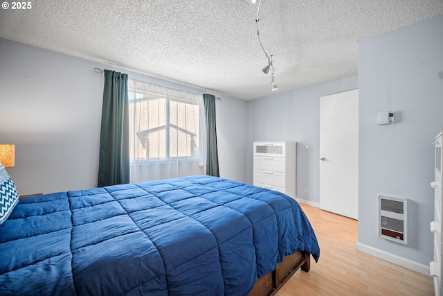 621 SE 121st Ave Unit 29, Vancouver, WA 98683 - bedroom featuring track lighting, light wood-style flooring, heating unit, and a textured ceiling